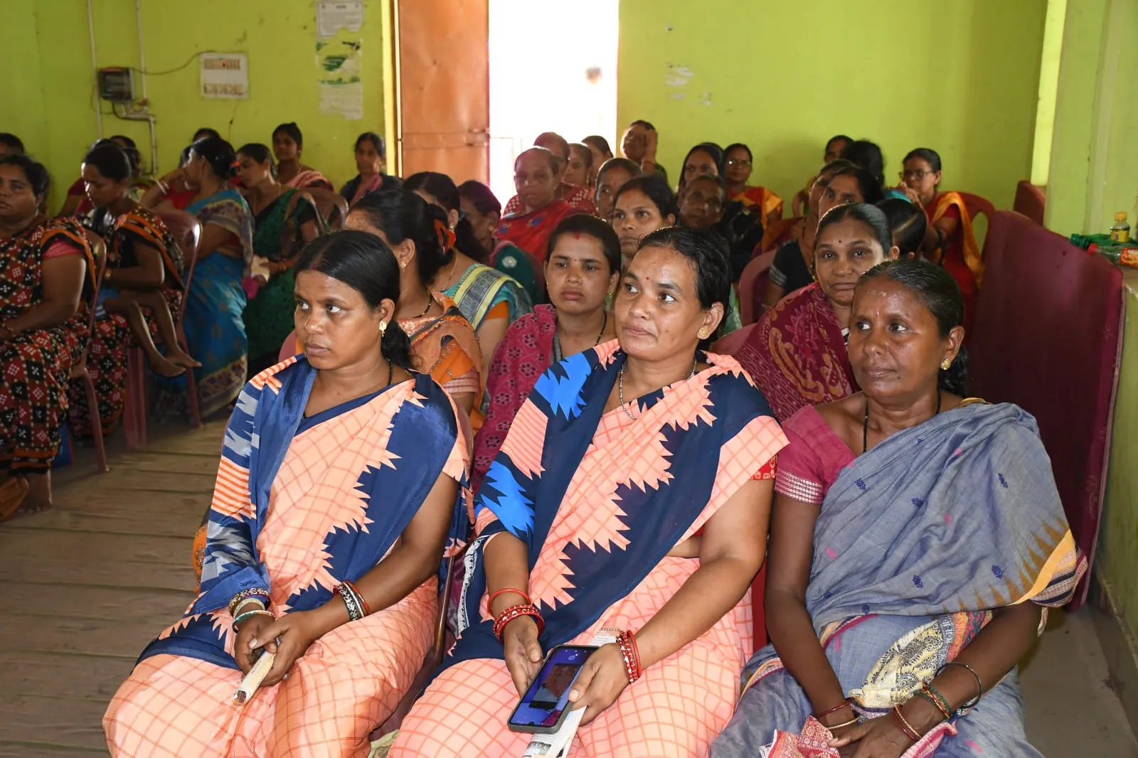 Members of several self-help groups seated at a village federation meeting
