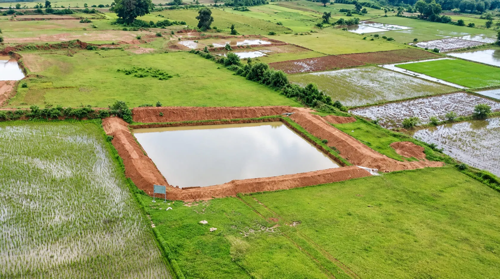 Aerial view of a water-harvesting structure set among treated farmland
