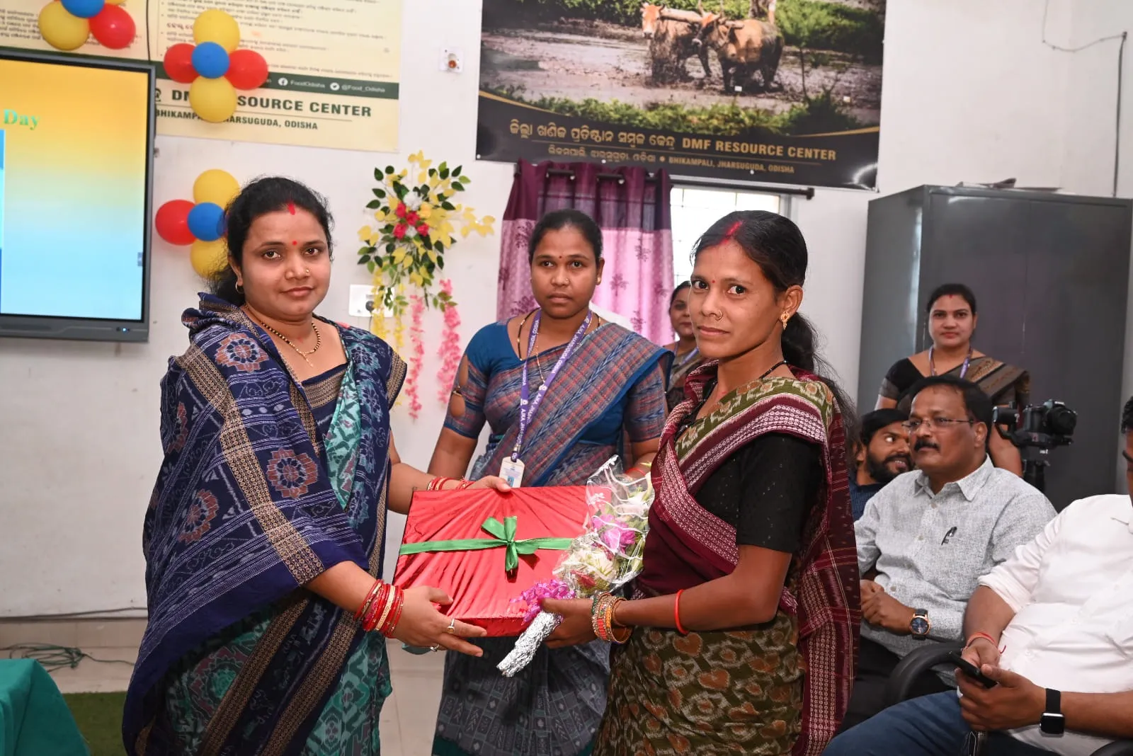 An AJKA staff member presenting an award to a woman farmer at the DMF Resource Centre in Bhikampali, Jharsuguda